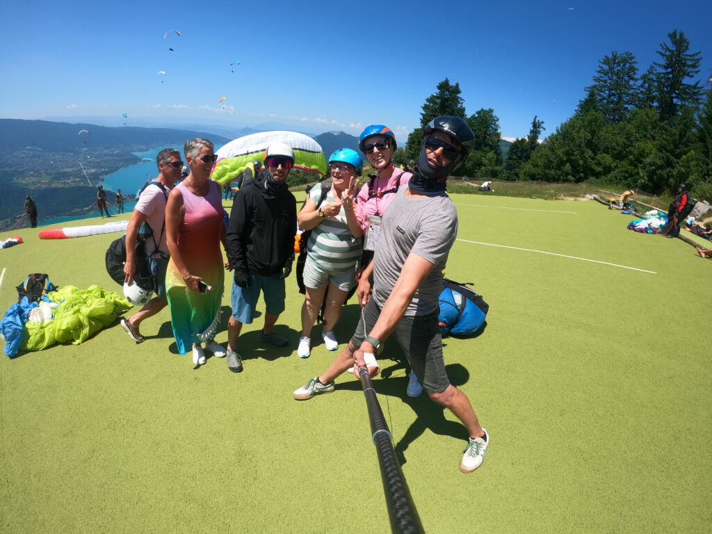 Une famille qui pose sur le décollage avant un vol vol en parapente bapteme.