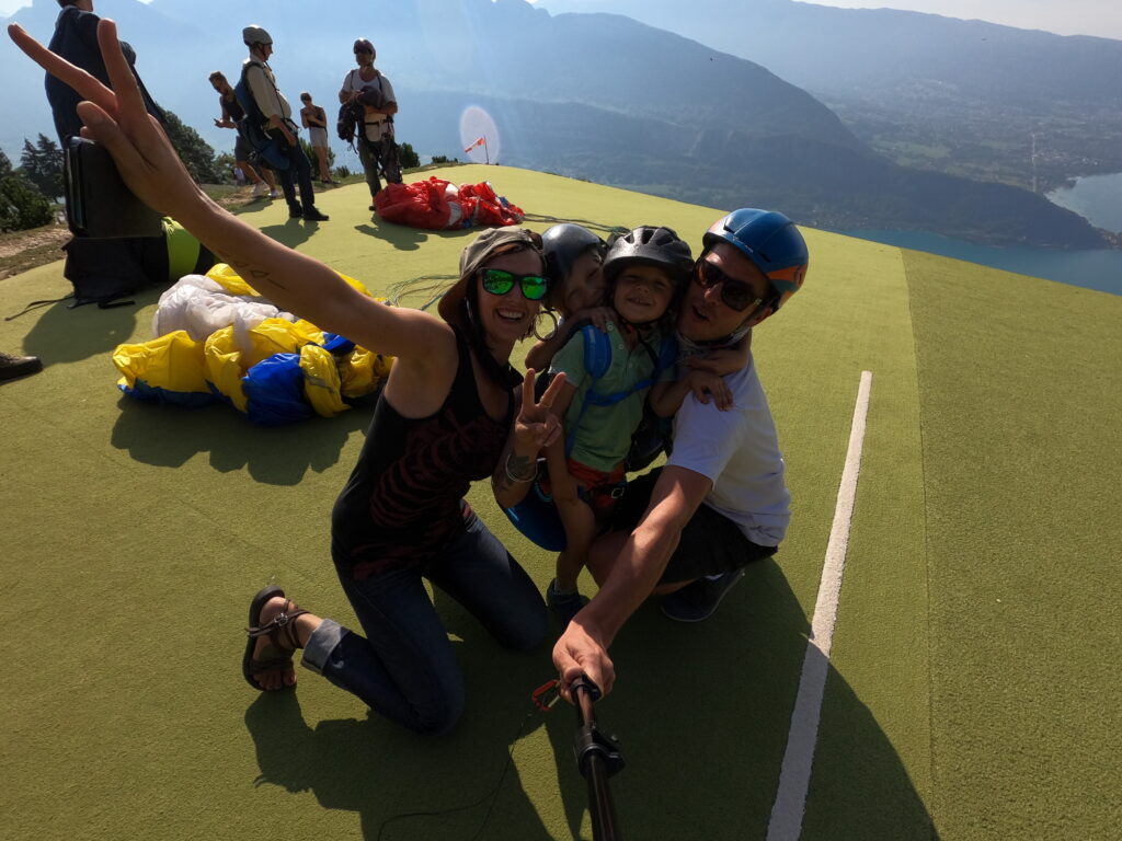 Une famille heureuse avant un décollage en parapente avec push up parapente.