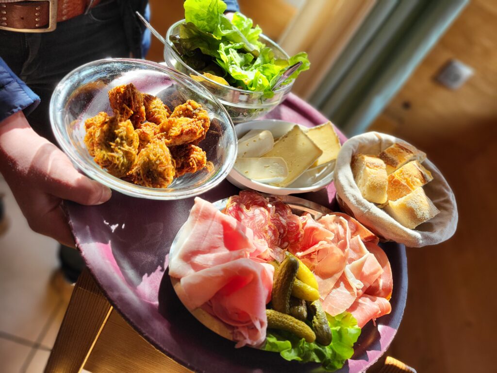 Plateau avec beignets de pomme de terre charcuterie salade et fromages de La Ferme restaurant au col de la forclaz